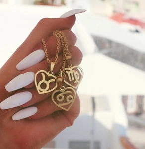 Gold-plated stainless steel heart pendant necklace featuring zodiac symbols on link chain