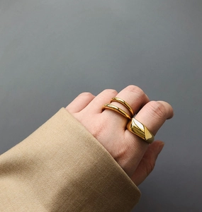 Chevalière dorée polie et bagues superposées pour un style minimaliste chic