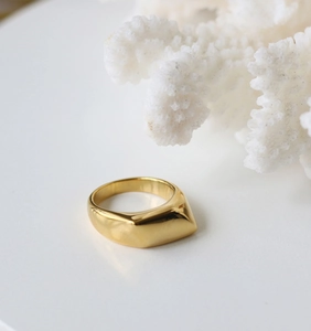 Bague minimaliste en acier inoxydable doré avec cône géométrique sur fond blanc pur