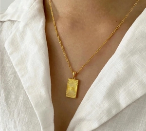 18K vergulde roestvrijstalen ketting met rechthoekige zonnehanger op wit shirt
