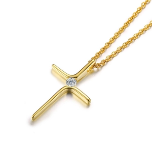 Nahaufnahme der minimalistischen goldenen Kreuzkette mit funkelndem Zirkon-Mittelstein