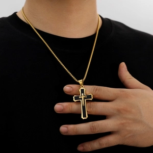 Men's retro cross pendant in gold and black steel on a gold box chain worn with a black shirt