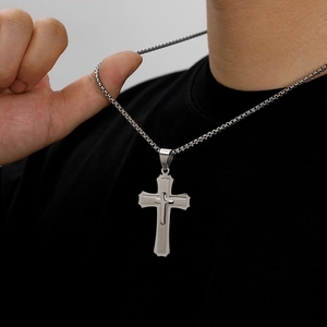 Detailed view of a multi-layer cross pendant with brushed metal finish on box chain