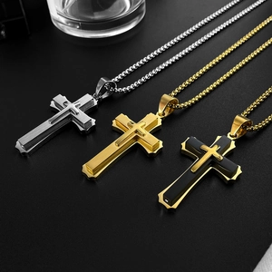 Macro shot of cross pendants in gold and silver steel on a modern textured black background
