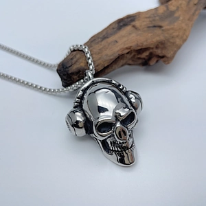 Gotischer Totenkopf-Anhänger mit Kopfhörern auf Vintage-Holz und quadratischer Kette