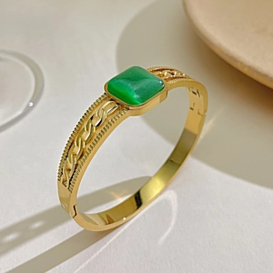 Detail of vintage hollow link gold bangle with rectangular green cat eye stone inlay