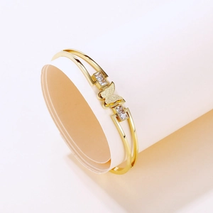 Detail of a gold butterfly bangle with frosted wings and sparkling zircon stones