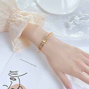 Close-up of gold butterfly open bangle with sparkling crystals on a model's wrist