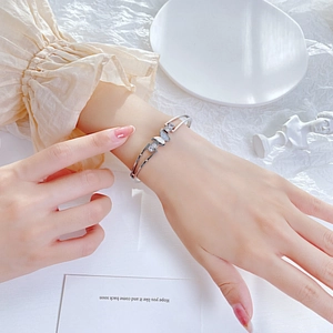 Elegant silver butterfly open bangle with zircon stones shown on a model's wrist