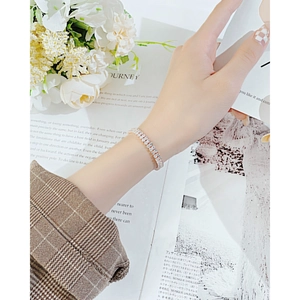 Bracelet de tennis élégant à trois rangées de cristaux or rose sur le poignet d'un mannequin