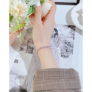Bracelet tennis élégant en or rose à double rangée de diamants porté sur un poignet doux
