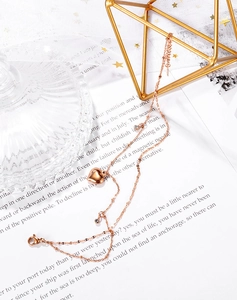 Macro shot of rose gold layered anklet featuring a polished heart pendant and sparkling zircons