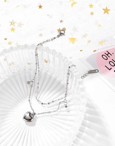 Detailed close-up of double-layer stainless steel heart anklet with s.steel tag