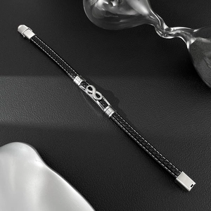 Detail view of black braided leather bracelet featuring silver infinity symbol and metal clasp