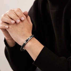 Men's braided black leather bracelet featuring a silver infinity charm for casual wear