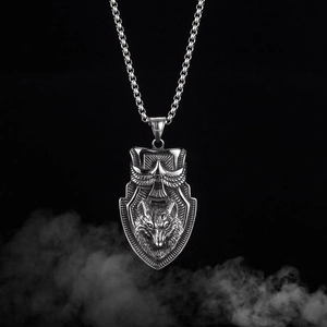 Detailed close-up of shield pendant featuring wolf and eagle motifs on box chain