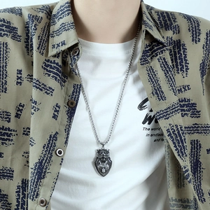 Close-up of vintage wolf head shield pendant in stainless steel on male model