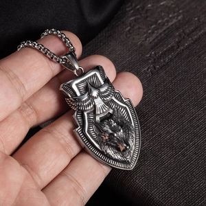 Detailed view of vintage silver shield pendant with eagle and wolf head relief