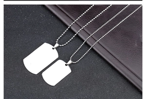 Detailed view of polished stainless steel dog tag pendants on round ball chain
