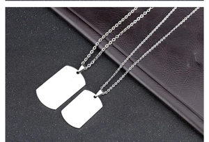 Macro shot of silver stainless steel dog tag pendants in large and small sizes