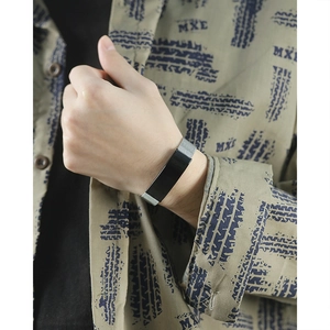 Détail d'une barre en acier noir réglable avec bracelet en maille argentée au poignet