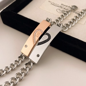 Dettaglio macro dei bracciali di coppia con cuore a puzzle e incisioni eleganti