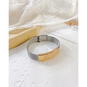 Détail d'un bracelet en maille réglable en acier inoxydable avec barre dorée