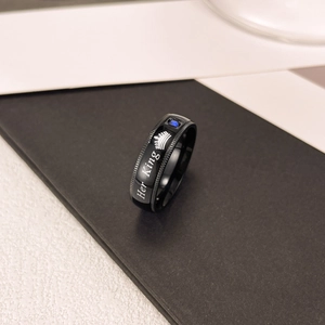 Dettaglio dell'anello Her King in titanio nero con corona e pietra preziosa blu