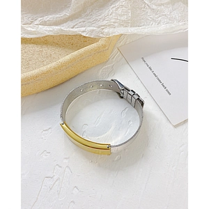 Détail du bracelet en maille argentée avec plaque dorée ajustable pour gravure
