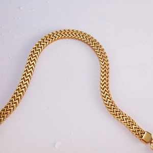 Detailed macro view of flat wavy weave pattern on a gold-plated stainless steel chain