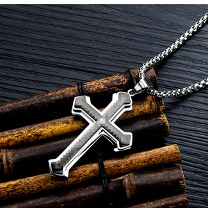 Detail of double-layer steel cross pendant with carbon fiber texture on bamboo