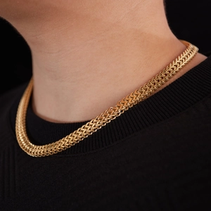Polished chunky gold stainless steel woven link chain necklace for men shown on a model