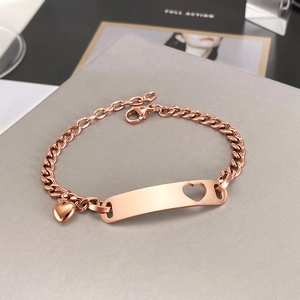 Detailed macro of rose gold stainless steel bracelet with heart cutout and small pendant