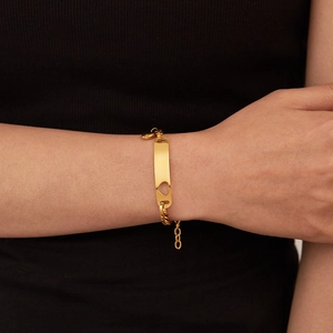 Detail of gold-plated stainless steel bracelet with cutout heart rectangular plate