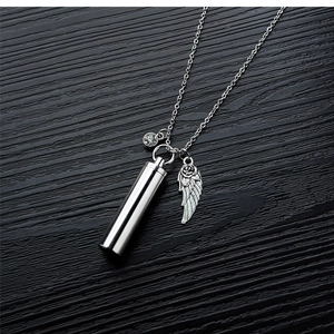 Detail view of silver stainless steel urn pendant with wings and zircon on wood