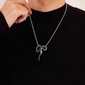 Detailopname van vintage punk slangenhanger in zilver titaniumstaal op zwarte trui