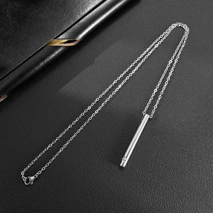 Détail macro du pendentif cylindrique argenté avec zircon sur fond en cuir noir élégant
