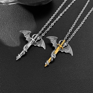 Detail von gotischen Drachenschwert-Anhängern in Silber und Gold auf schwarzem Leder