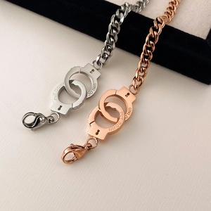 Detail of silver and rose gold handcuff bracelets with Put Down and Unlock engraving