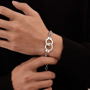 Detailed close-up of silver handcuff bracelet with engraved Unlock and Put Down words