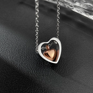 Dettaglio del ciondolo a cuore in argento e oro rosa su una catena sottile