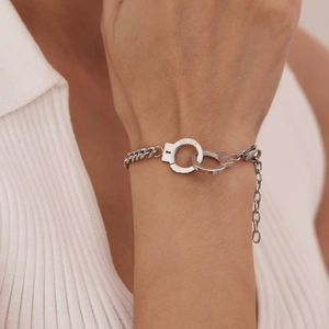 Polished stainless steel handcuff link bracelet with UNLOCK engraving on model wrist