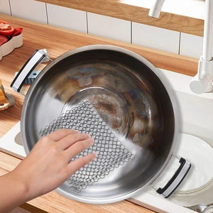 304 stainless steel chainmail scrubber cleaning a burnt pot in a kitchen sink