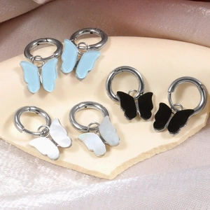 Three pairs of colorful butterfly drop hoop earrings in blue, black, and white colors