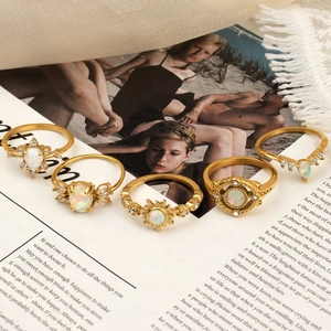 5-piece vintage bohemian gold ring set with opal stones and sunflower accents on magazine