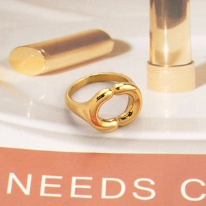 Detailed shot of an irregular geometric 18k gold plated stainless steel ring on a magazine