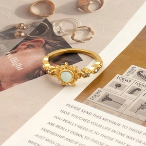 Detail of vintage sunburst titanium ring with iridescent opal-like stone and gold finish