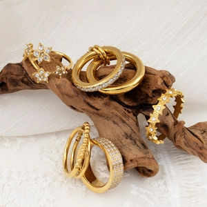 Set de anillos dorados de 18k en capas con circonitas de estrella sobre madera