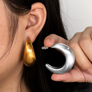 Dicke C-förmige Chunky-Ohrringe in 18K Gold und Silber-Finish auf neutralem Grund