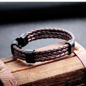 Detail of multi-layer braided brown leather bracelet with matte black magnetic metal clasp